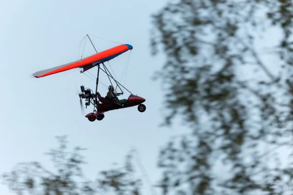 A paragliding az alacsony elsöprő repülés alatt fák — Stock Fotó