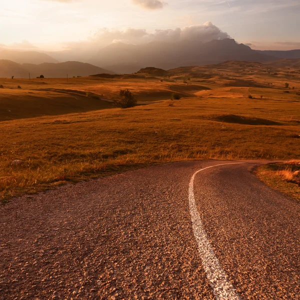 Driving on an empty road at sunset — Stock Photo, Image