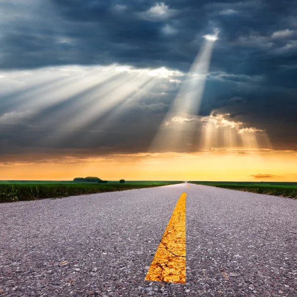 Condução em estrada de asfalto em direção aos raios de sol — Fotografia de Stock