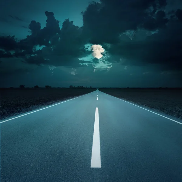 Guida notturna su una strada vuota verso la luna — Foto Stock