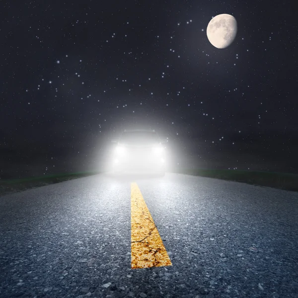 Guida notturna su strada asfaltata verso i fari — Foto Stock