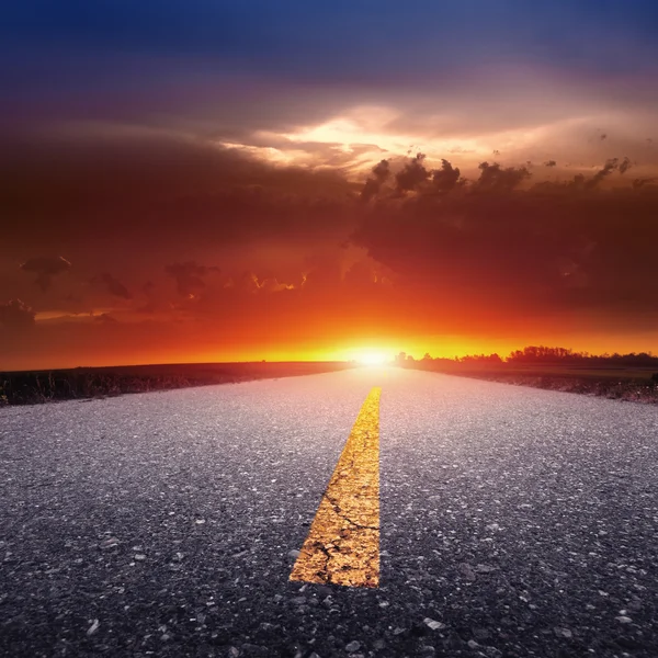 Driving on an empty country road at sunset — Stock Photo, Image