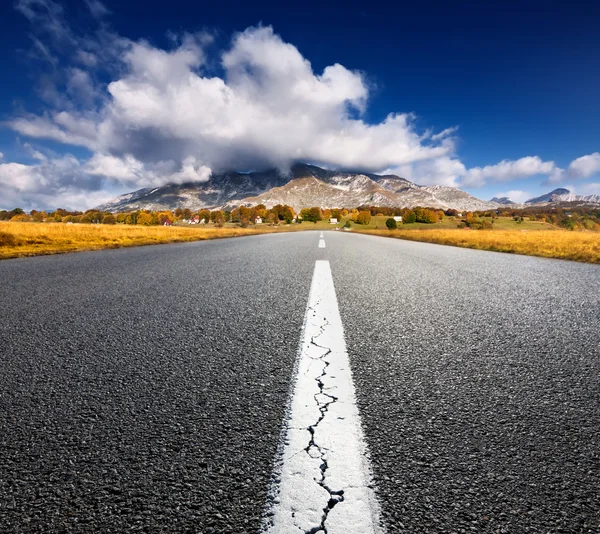 Conduciendo por un camino de asfalto vacío a las montañas — Foto de Stock