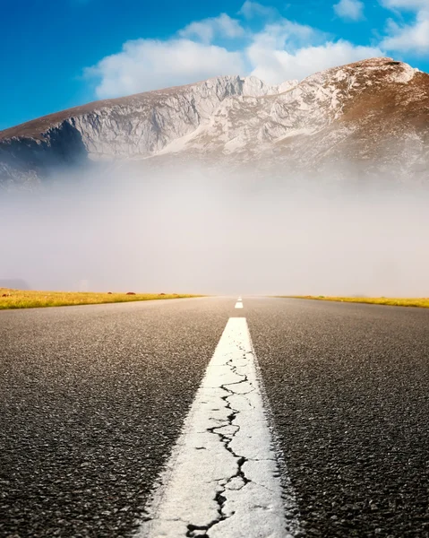 Driving on an empty asphalt road at the misty mountains — Stock Photo, Image