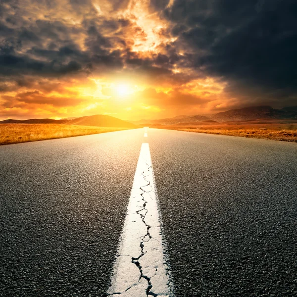 Driving on  asphalt road towards the setting sun — Stock Photo, Image