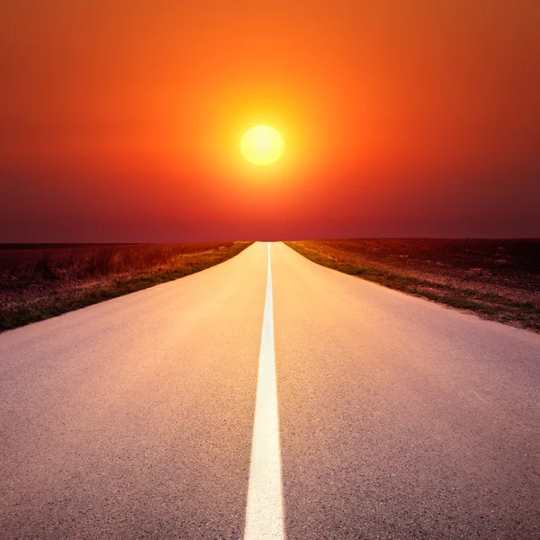 Driving on an empty asphalt road at sunset — Stock Photo, Image