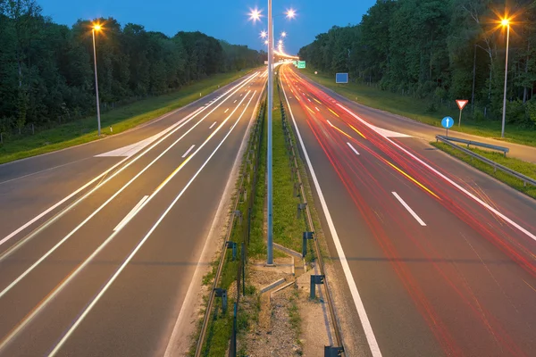 Carretera con senderos ligeros al atardecer —  Fotos de Stock