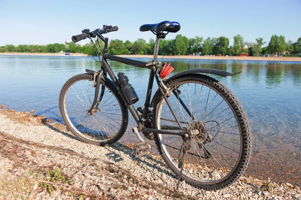 Rower na brzegu krystalicznie czyste jeziora — Zdjęcie stockowe