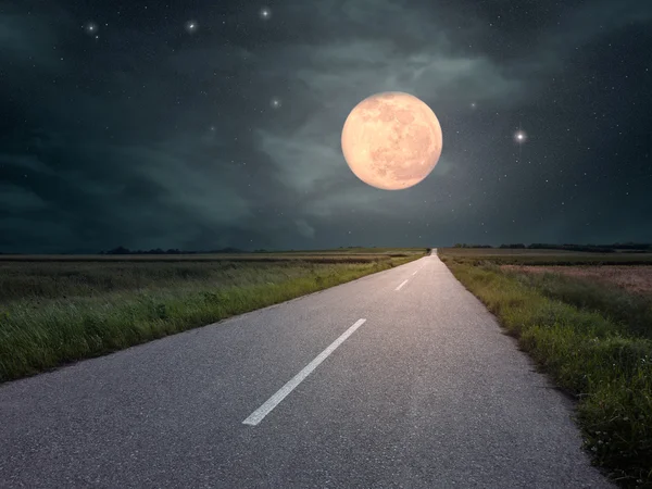 Driving on an empty road towards the moon — Stock Photo, Image