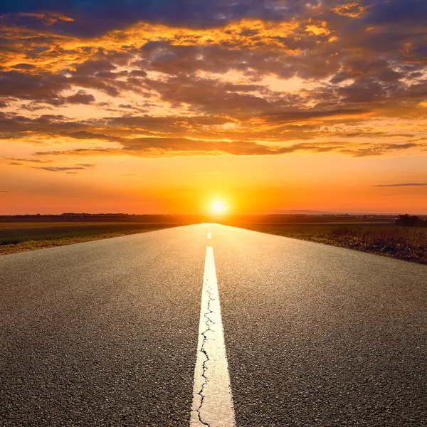 Driving on an empty road towards the sunset — Stock Photo, Image