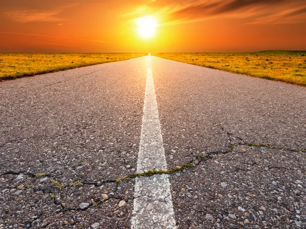 Conduciendo por un camino de asfalto vacío hacia el sol —  Fotos de Stock