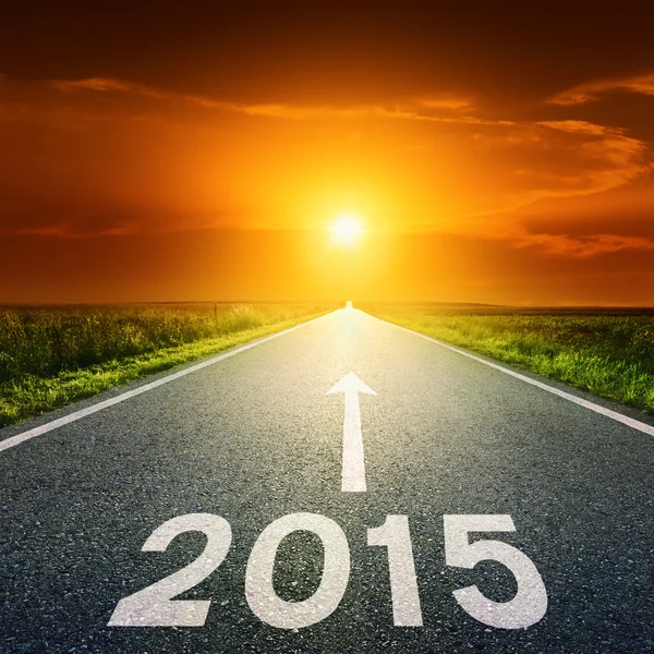 Driving on an empty road towards the sun to 2015 — Stock Photo, Image