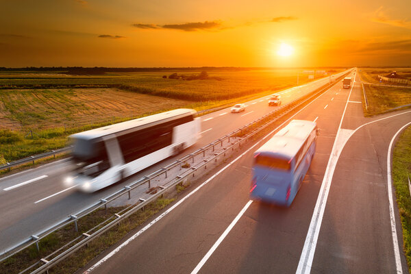 Two buses on highway in motion blur