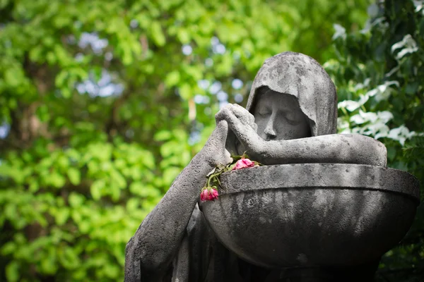 Mourning statue with withered flowers — Stock Photo, Image