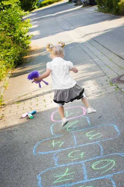 Ragazza che gioca Hopscotch Immagini Stock Royalty Free