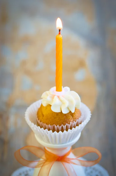 Палаюча свічка на крихітному кексі на день народження — стокове фото