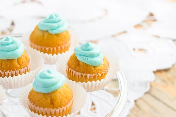 Schöne Cupcakes mit türkisfarbenem Zuckerguss und weißen Perlen dekoriert — Stockfoto