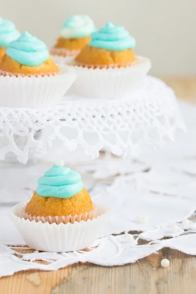 Schöne Cupcakes mit türkisfarbenem Zuckerguss und weißen Perlen dekoriert — Stockfoto