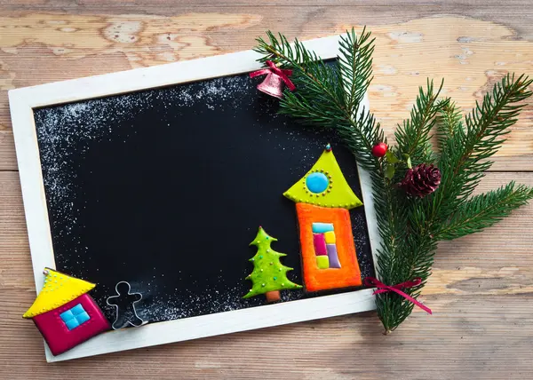 Quadro negro decorado com biscoitos coloridos e ramo de abeto — Fotografia de Stock