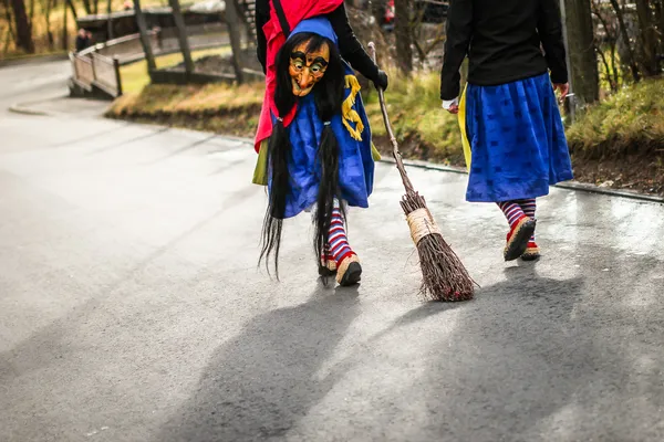 Traditional carnival in South Germany - Swabian-Alemannic Fastnacht. Two witches walking down the street. Selective focus on broom. — Stock Photo, Image