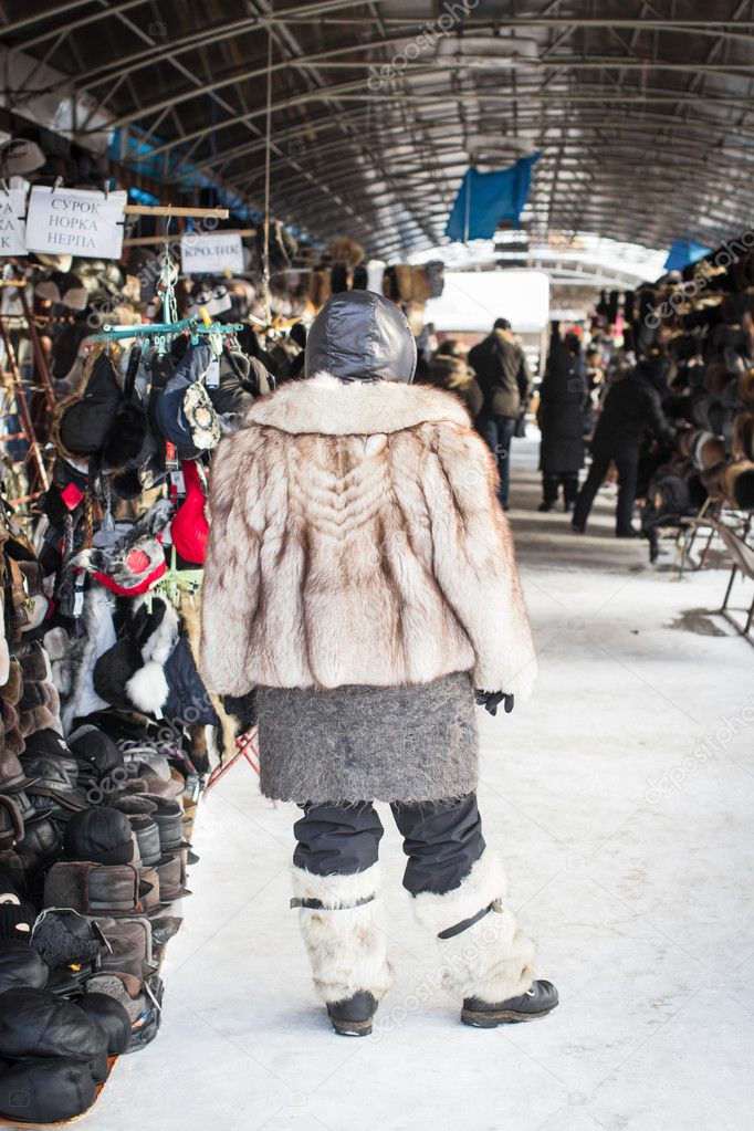 Woman in fur coat standing in the market