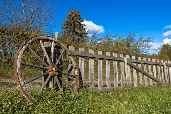 Old wheel and wooden fence — Stock Photo, Image