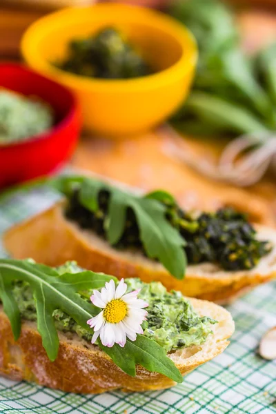 Baguette with green pesto and ruccola leaves — Stock Photo, Image