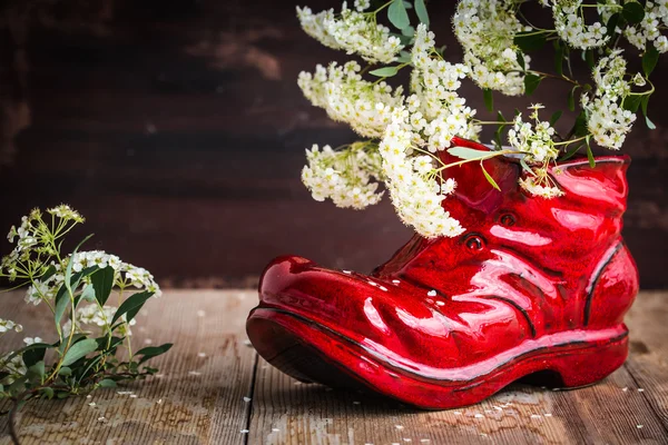 Jarrón de cerámica en forma de zapato viejo con flores blancas — Foto de Stock