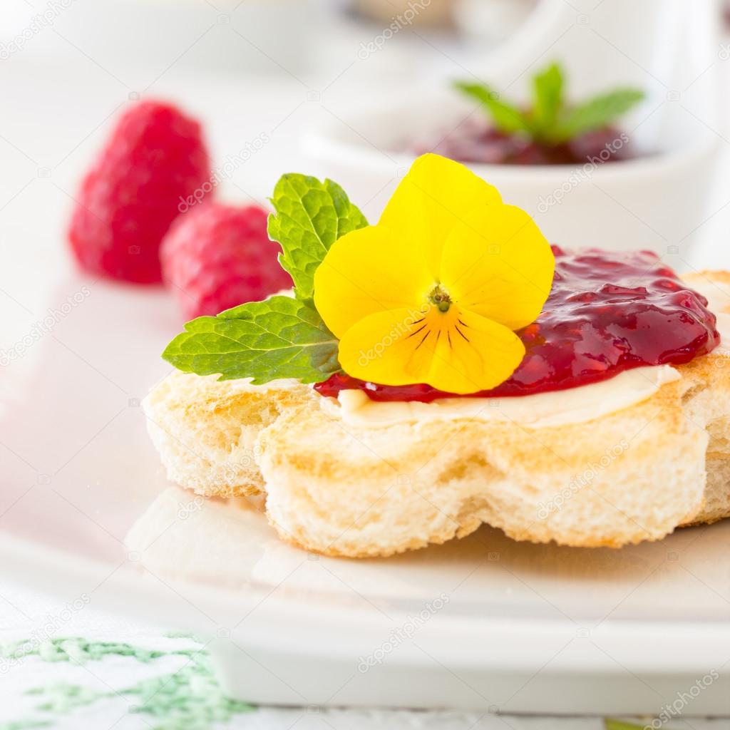 Crispy toast in flower shape with butter and raspberry jam