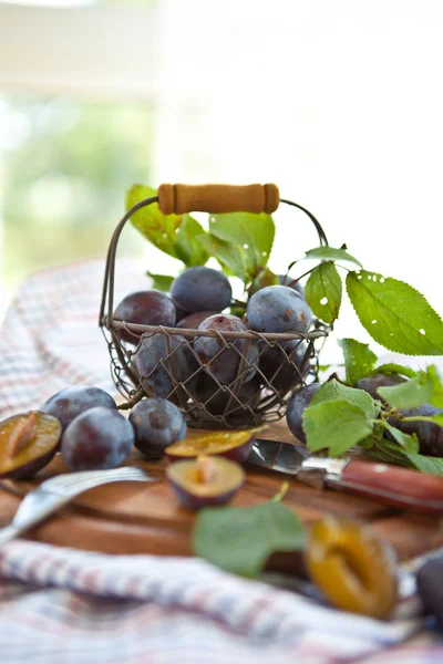 Prunes fraîches mûres dans de petits paniers en maille — Photo