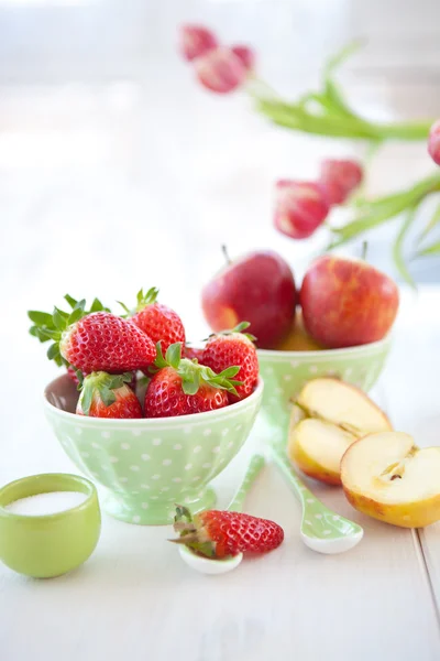 Fresh fruits in green vintage bowl and pink tulips — Stock Photo, Image