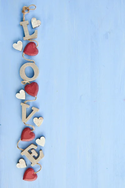 Blå bakgrund med trä bokstäver stavning kärlek — Stockfoto