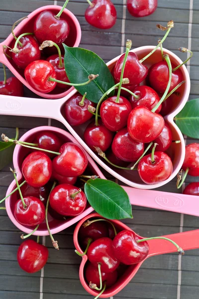 Fresh cherries in measuring cups — Stock Photo, Image