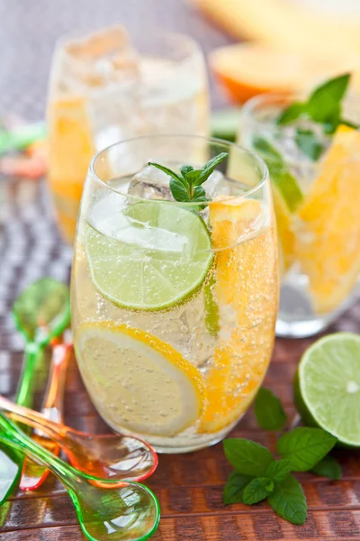 Cold drink with lemons and oranges — Stock Photo, Image