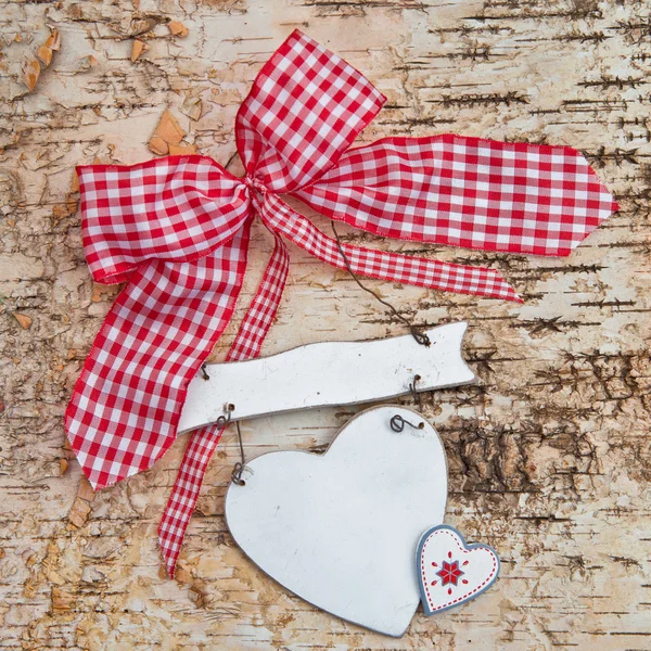 Corazón en blanco sobre fondo de madera con cinta roja — Foto de Stock