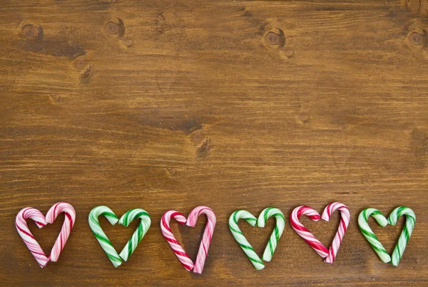 Colorful candy canes arranged in heart-shapes — Stock Photo, Image
