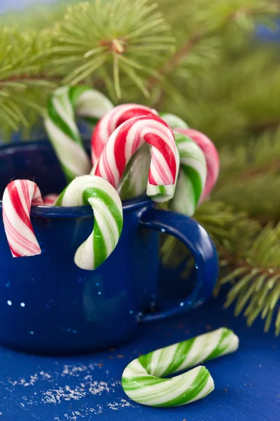 Candy canes in blue cup — Stock Photo, Image