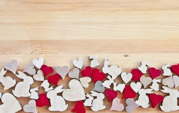 Wooden background with hearts and easter bunnies — Stock Photo, Image