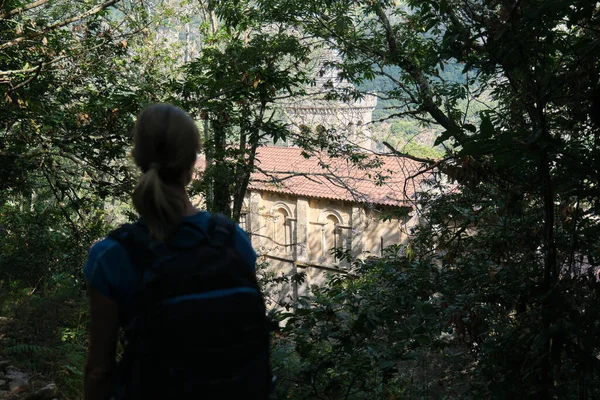 Turista admirando el monasterio de Santa Cristina desde un sendero forestal — Foto de Stock