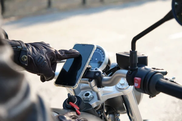 Крупним планом людини, що використовує мобільний телефон на мотоциклі — стокове фото