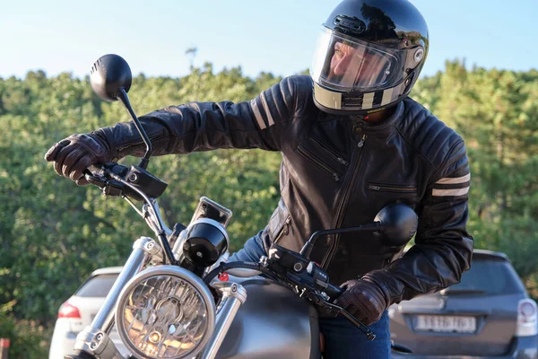 Motosikletli kasklı bir motosikletli.