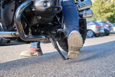 Motosikletlinin kickstand 'ı yerleştirirken yakın plan çekimi.