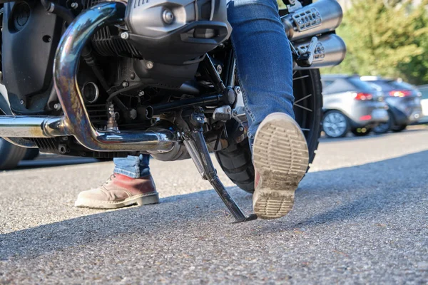 Motosikletlinin kickstand 'ı yerleştirirken yakın plan çekimi.