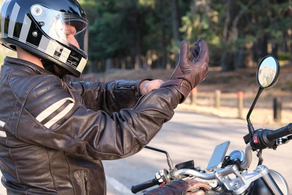 Um motociclista coloca luvas antes de andar de moto — Fotografia de Stock
