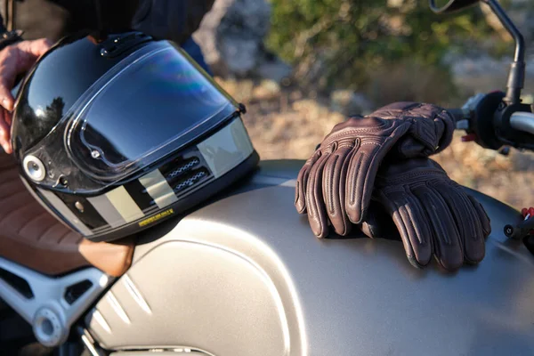 Luvas e capacete em um tanque de motocicleta — Fotografia de Stock