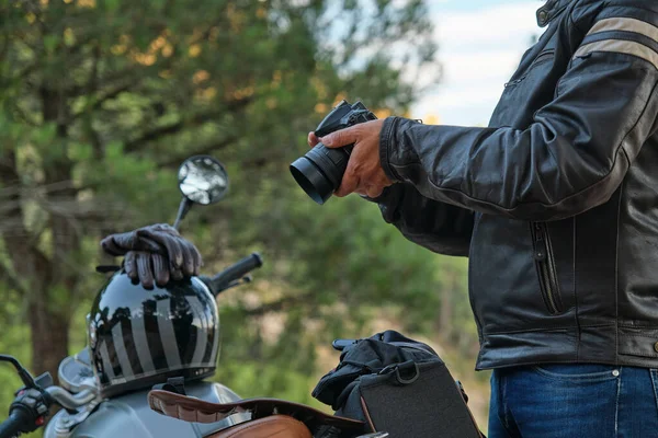 Чоловік з камерою в руці поруч з мотоциклом . — стокове фото