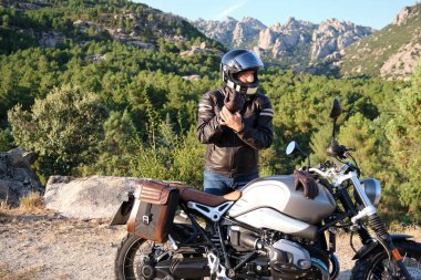 Motosiklete binmeden önce bir motorcu eldiven giyer.