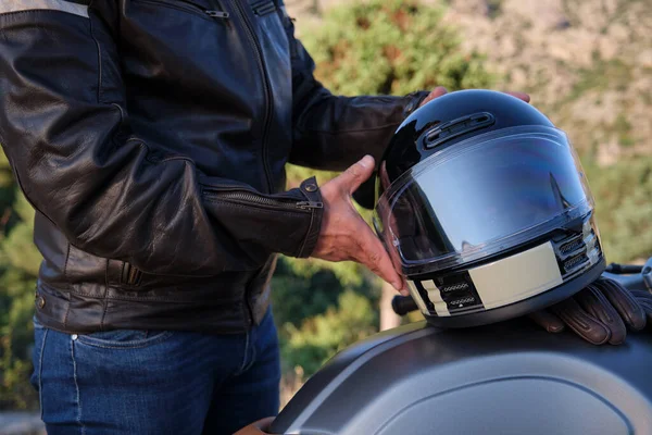 Невпізнаваний чоловік кладе шолом на мотоцикл — стокове фото