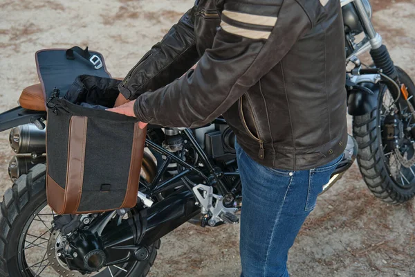Невпізнаваний чоловік прибирає багаж з мотоцикла під час перерви — стокове фото