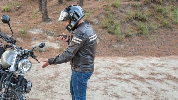 Biker berbicara di telepon kepada asuransi motornya setelah mengalami gangguan di jalan. — Stok Foto
